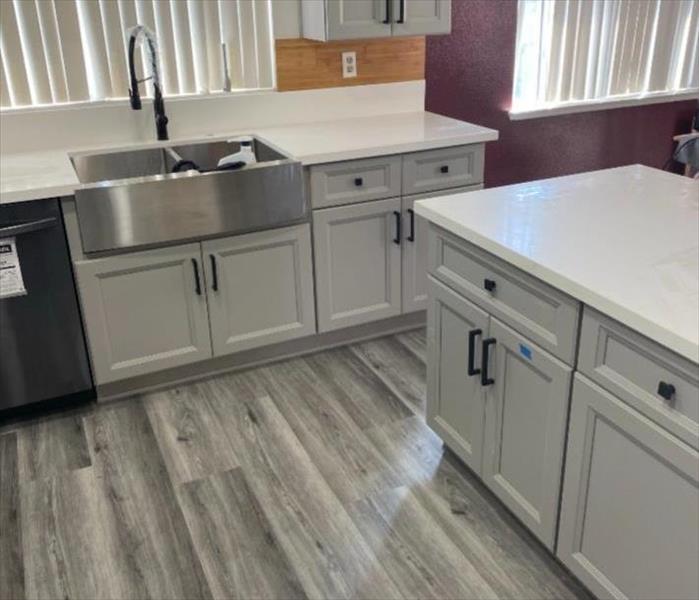 New clean kitchen. White cabinets and grey floors. 