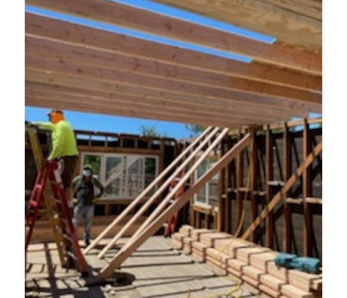 Construction site showing a home standing without ceiling, roofing or walls only showing the framing.