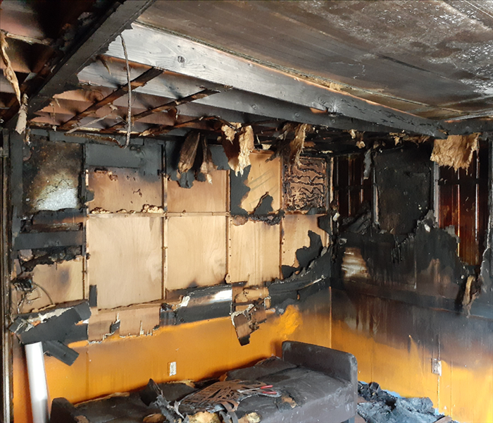Damaged room due to fire. Black soot and fire damage on the walls.